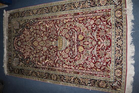 An Indian silk red ground rug